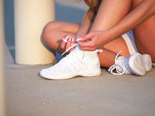 Cheerleader tying Rebel cheer shoe