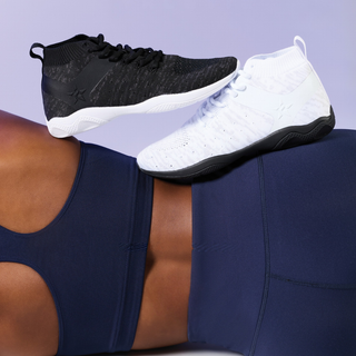 Shoes on women laying sideways on ground with purple background 