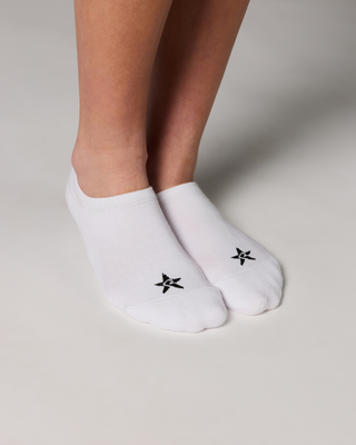 White socks with black star design worn by a person on a neutral background