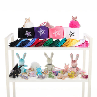 Shelf with colorful bags and small stuffed toys on a white background