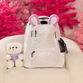 Sparkly backpack with bunny ears and a small teddy bear on a pink floral background