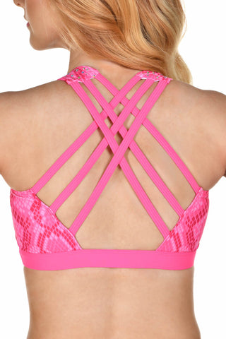 A close-up back view of a woman wearing a bright pink sports bra with a snakeskin pattern and crisscrossing strappy back details.