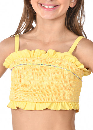 Yellow ruffled top worn by a child on a white background