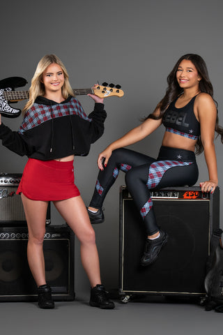 two girls in the rebel athletic plaid punk rock collection in black white and red with guitars and amps